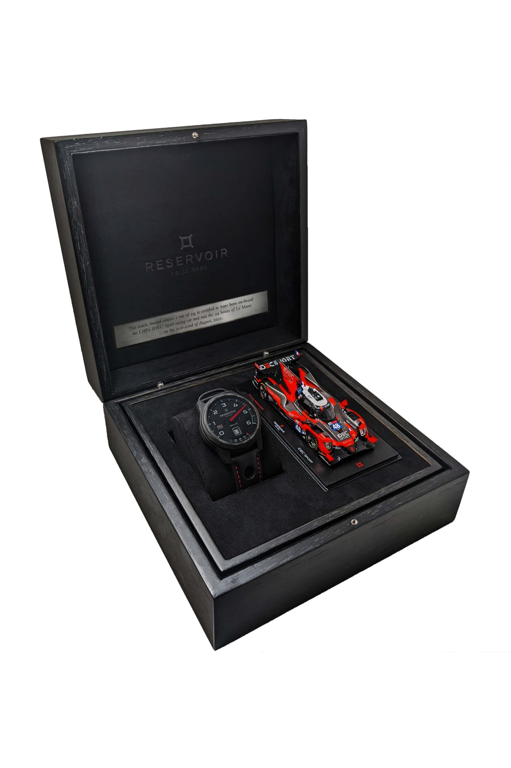 Luxury watch and detailed model racing car in a black presentation box labeled "RESERVOIR".