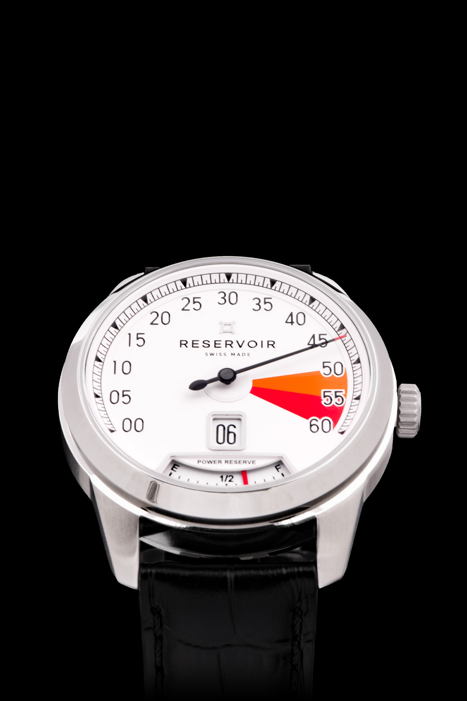 Gros plan sur une montre-bracelet "RESERVOIR", cadran blanc, affichage analogique, cuir noir bracelet.
