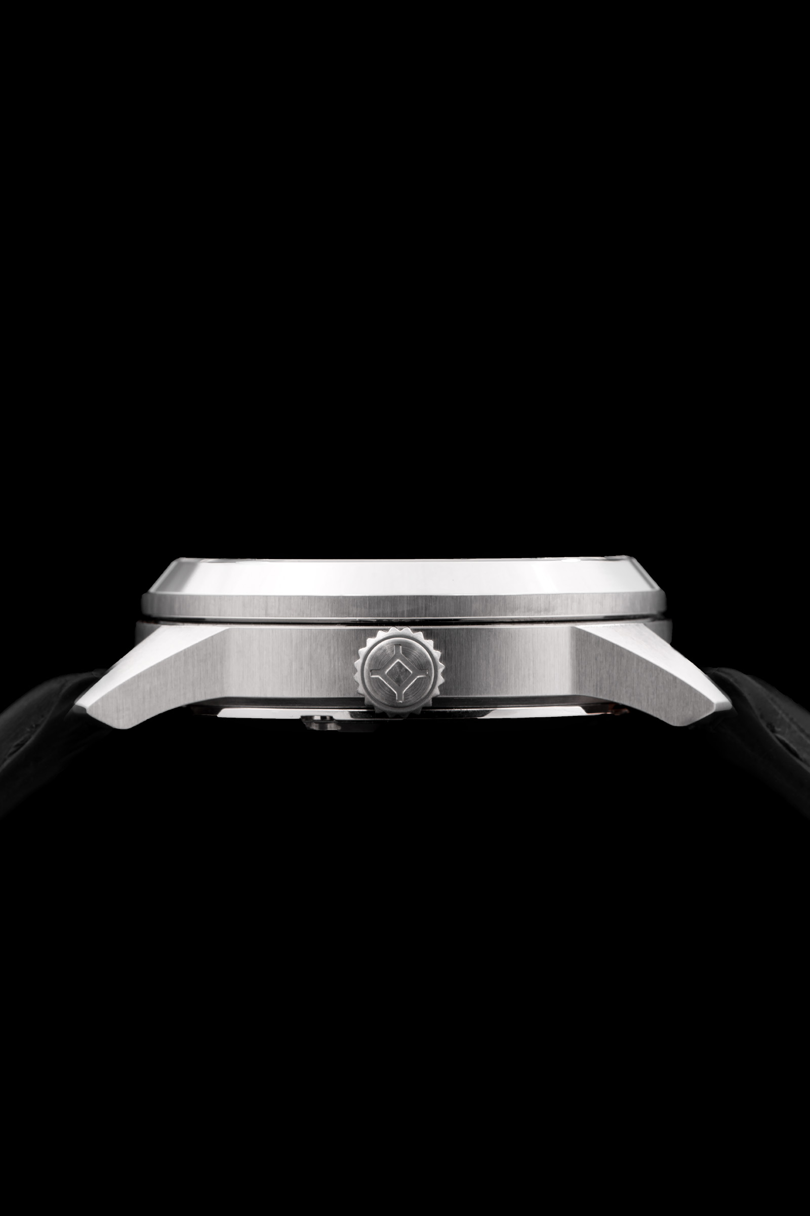 Montre en acier inoxydable boîtier profil latéral avec bracelet noir, couronne texturée, fond noir.