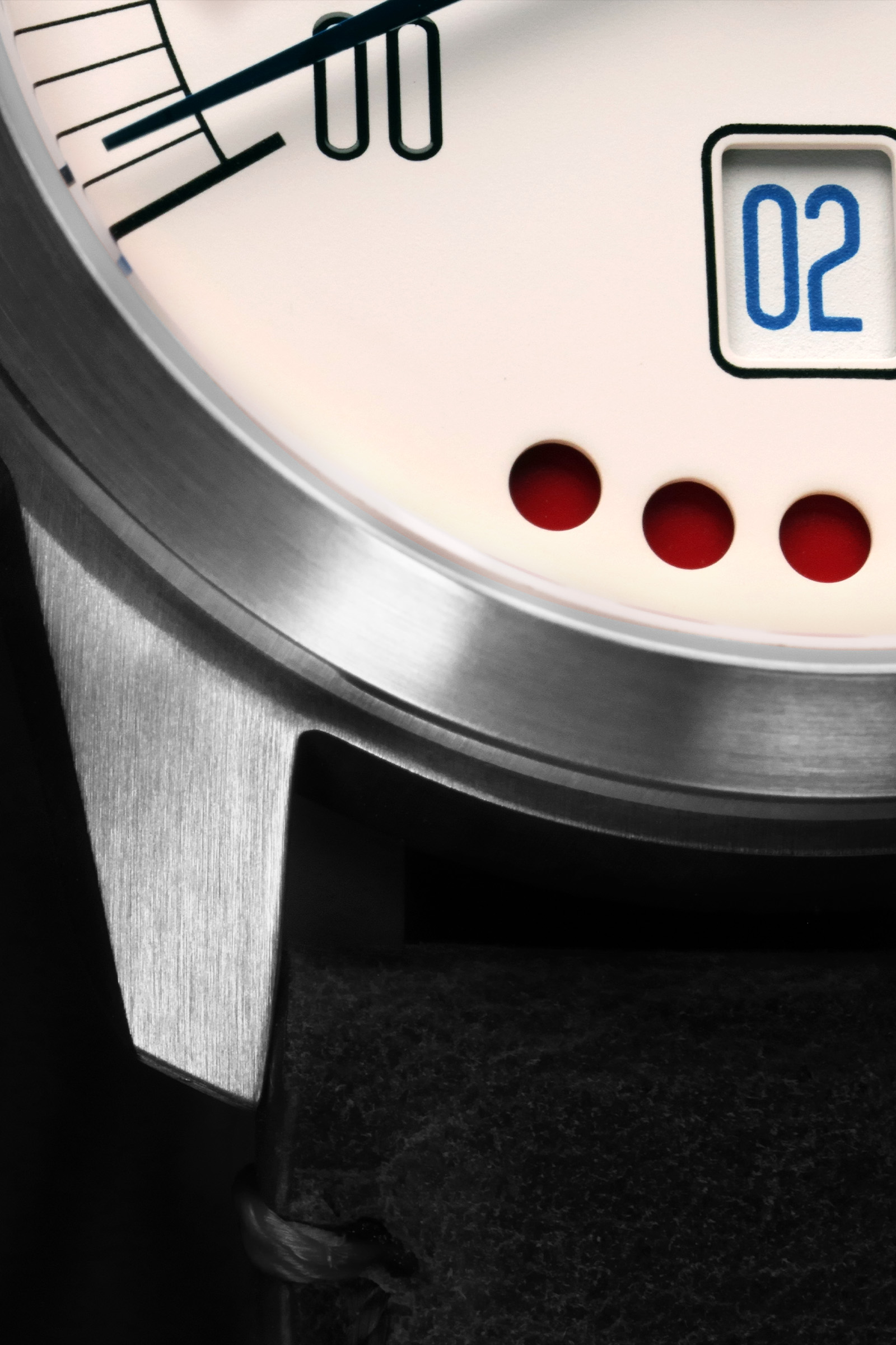Close-up of a wristwatch dial with date "02", seconds hand, markers, and three red indicators.