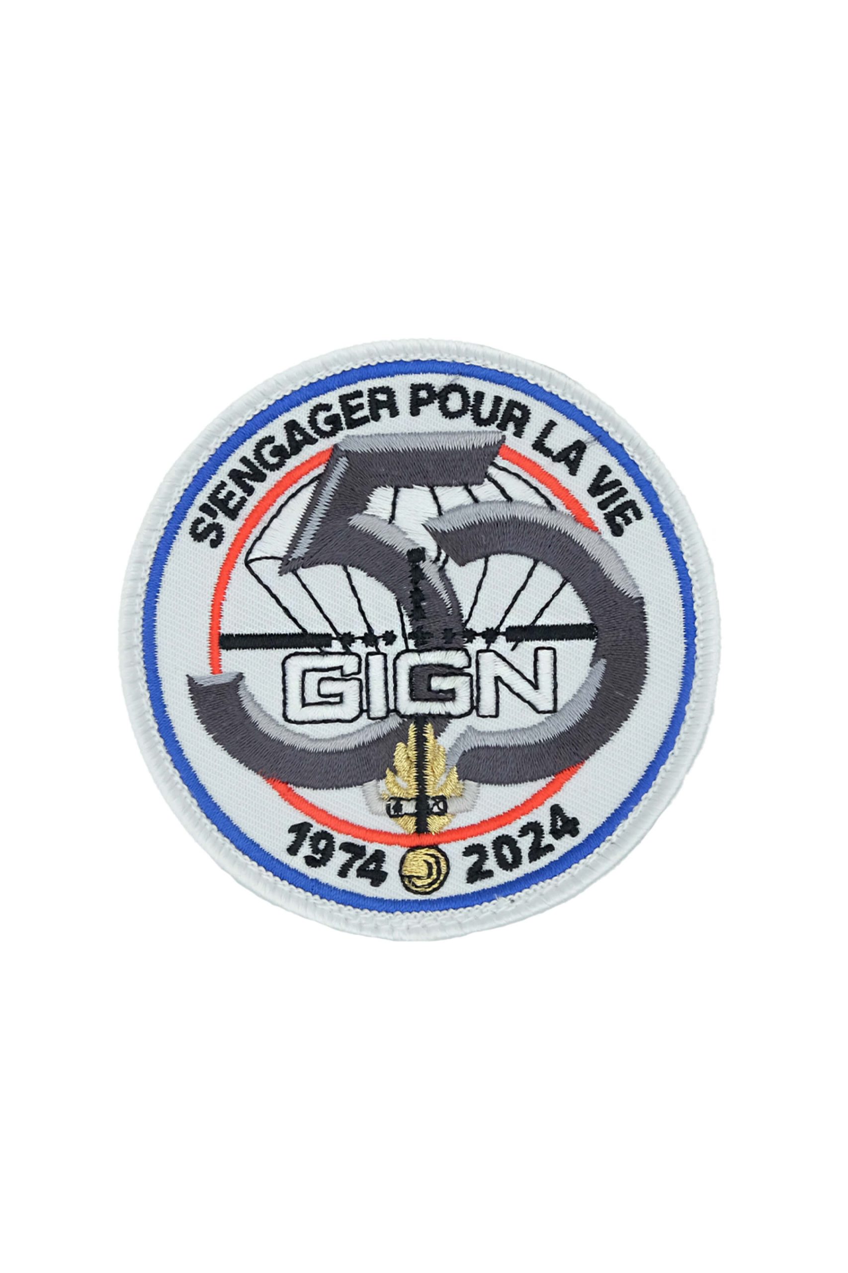 Emblème circulaire avec "S'ENGAGER POUR LA VIE", dates 1974-2024, GIGN, et un motif de flamme d'épée.