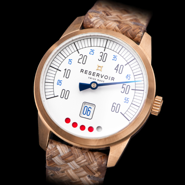 Wristwatch with white dial, single hand, blue/black numerals, date window, woven strap, gold case.