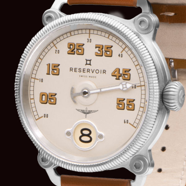 Close-up of a Reservoir analog wristwatch with numeric markings and a circular hour window showing "8".