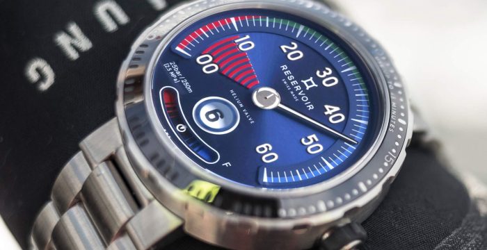 Close-up of a metallic wristwatch with a blue dial and colorful indicators.