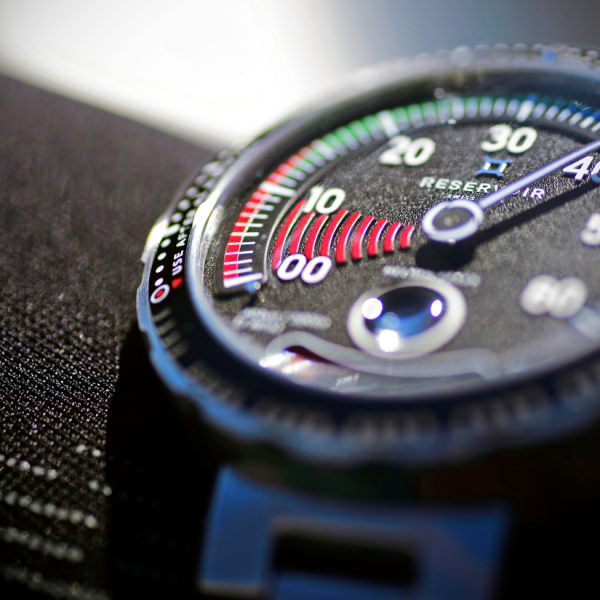 Macro shot of wristwatch face with a segmented gauge, numerical indicators, and colored sections.