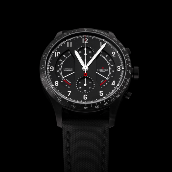 Black analog wristwatch with tachymeter bezel, three sub-dials, Arabic numerals, leather strap.