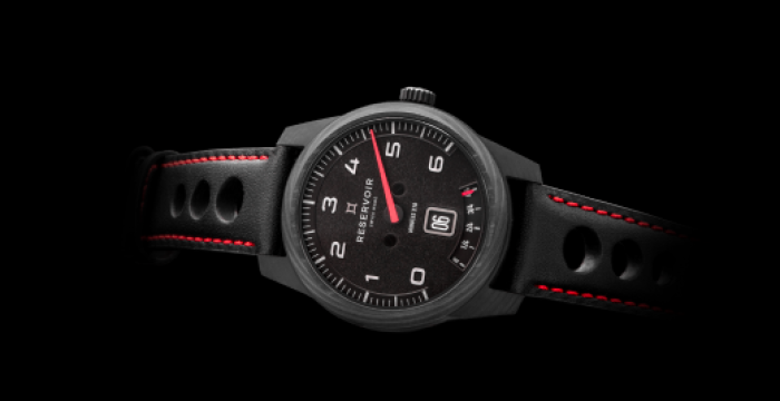 Black wristwatch with white numerals, date display, red accents, perforated holes, and red stitching.