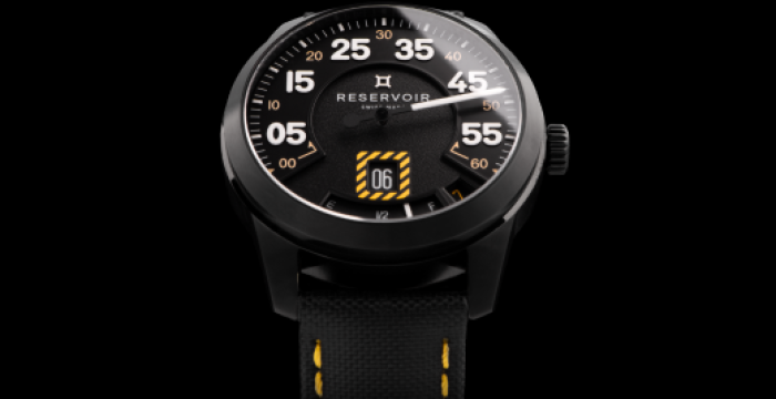 Montre-bracelet noire avec cadran rond, chiffres blancs, accents jaunes, et bracelet noir avec surpiqûres jaunes.
