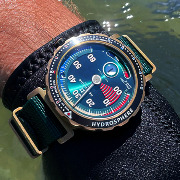 Diver's wristwatch submerged in water, colorful dial, green strap, bronze hardware, "HYDROSPHERE" bezel.