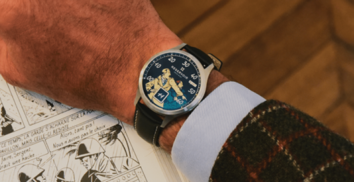 Wristwatch with illustrated dial, arm resting on an open black-and-white comic book, patterned jacket.
