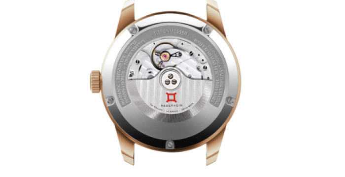Mechanical wristwatch back with transparent case, revealing intricate gears and branding engravings.