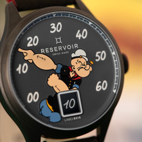 Close-up of a Reservoir wristwatch with a cartoon sailor on the black dial and a retrograde minute display.