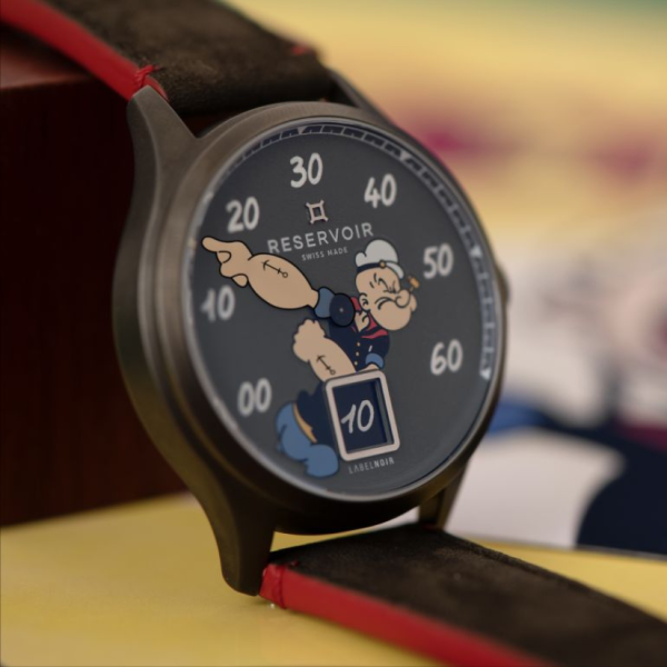 Wristwatch with black dial, character pointing, numeric indicators, "RESERVOIR SWISS MADE," black-red strap.
