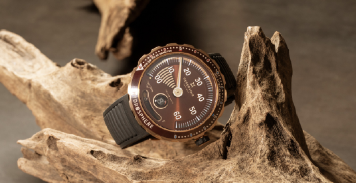 Wristwatch with brown dial, silver accents, black strap on driftwood, dark background, unique design.